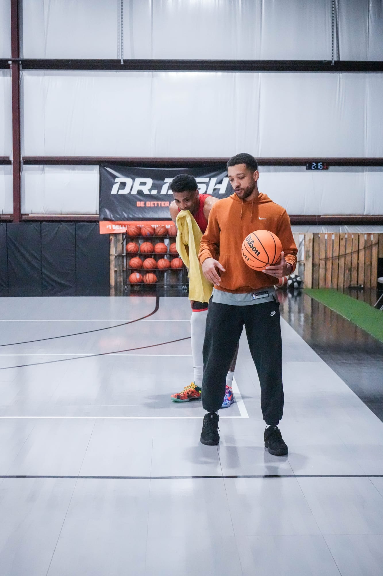Coach Kyle Randall giving one-on-one instruction beside the Dr. Dish shooting machine